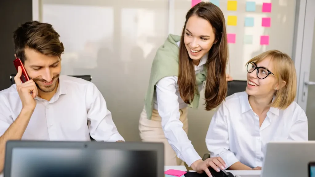 Equipe de 1 homem e 2 mulheres trabalhando com felicidade corporativa