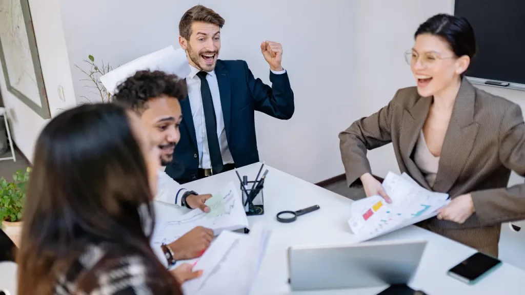 Reunião com 4 pessoas demonstrando felicidade corporativa
